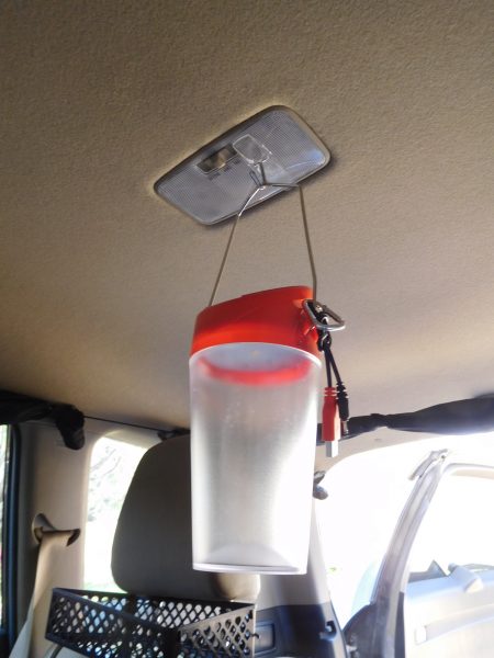 I stuck a 3M Command hook (the adhesive hooks that you can remove by pulling a tab) into the light in the middle of the back of the SUV, and I hang the lantern from the hook.