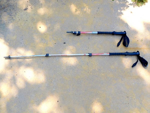 Two trekking poles. The top one is collapsed, and the bottom one is extended.