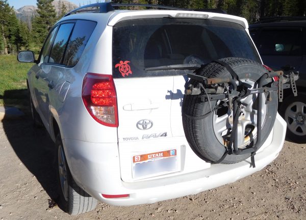 A RAV4 with a bike rack attached to the spare tire.