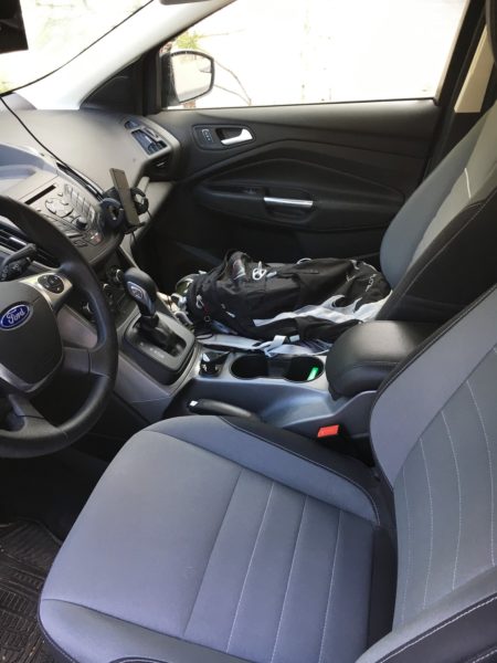A side look at the two front seats. He's using the front seat and the floor in front of the seat for storage. Note also the vent-mounted phone holder and signal booster.