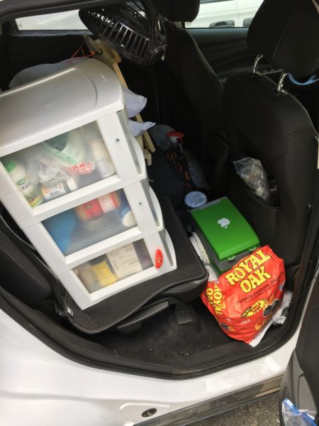 Looking at the back seats through the rear passenger side door. A plastic bin on the seat provides a bunch of great storage. On the floor in front of the seat is 